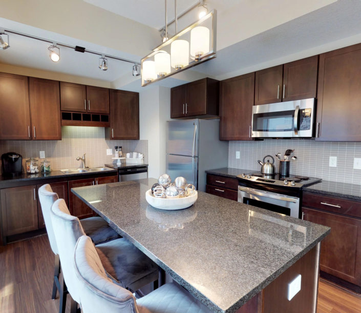 Guest suite kitchen with granite countertops and stainless steel appliances